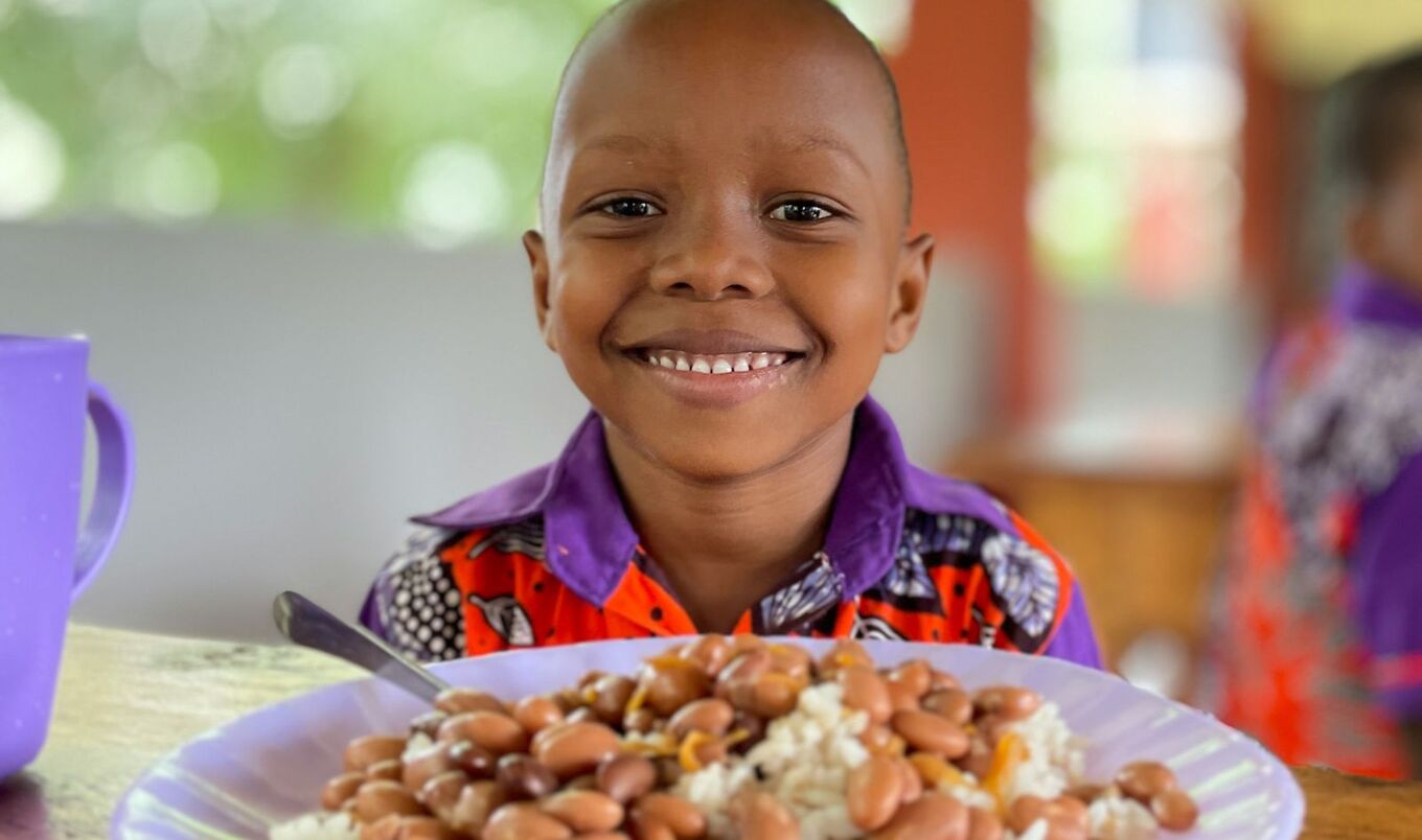 little boy with plate of beans